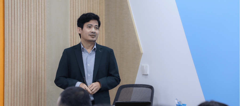 Mr. Sim Chankiriroth, Vice President of YEAC, pointing to a diagram on an interactive whiteboard that explains the financial reporting period and approval process during a training session for Cambodian entrepreneurs.